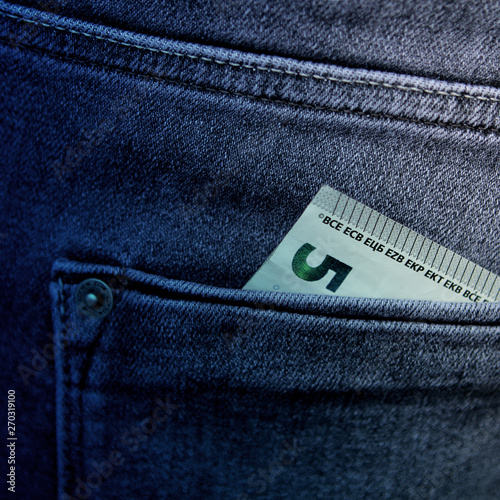 5 Euro banknote in the back pocket of men's blue jeans, square, close-up