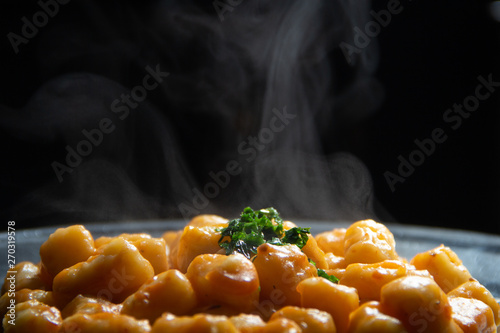 Nhoque de batata caseira com molho e salsa quentinho, saindo fumaça. photo