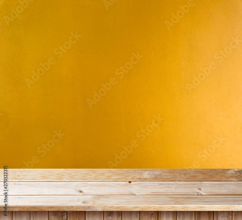 Table top wooden deck on yellow wall texture background