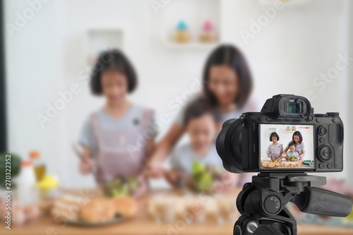 Mother and daughter cooking in the kitchen at home, With recording making video blogger camera for their blog