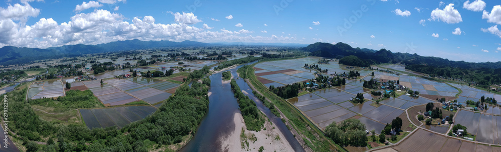Obraz premium 秋田県の田園風景 5月 田植え 水が張った水田 屋敷林 日本