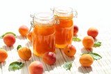 Apricot jam. Orange jam in glass jars set, fresh ripe apricots on a wooden white table on a light background. High key.Homemade jam.Summer  Canned fruit jam. Healthy vegetarian sweets