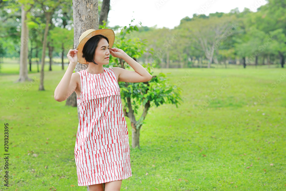 Fototapeta premium Beautiful young asian woman poses in the nature park.