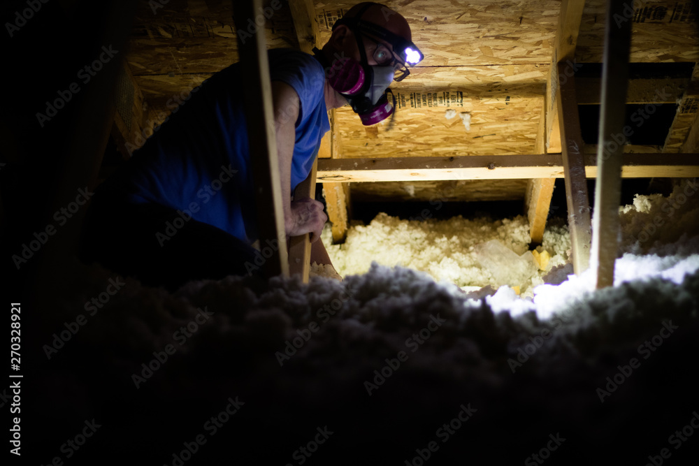 Working in a dark and dusty attic with insulation - obrazy, fototapety, plakaty 