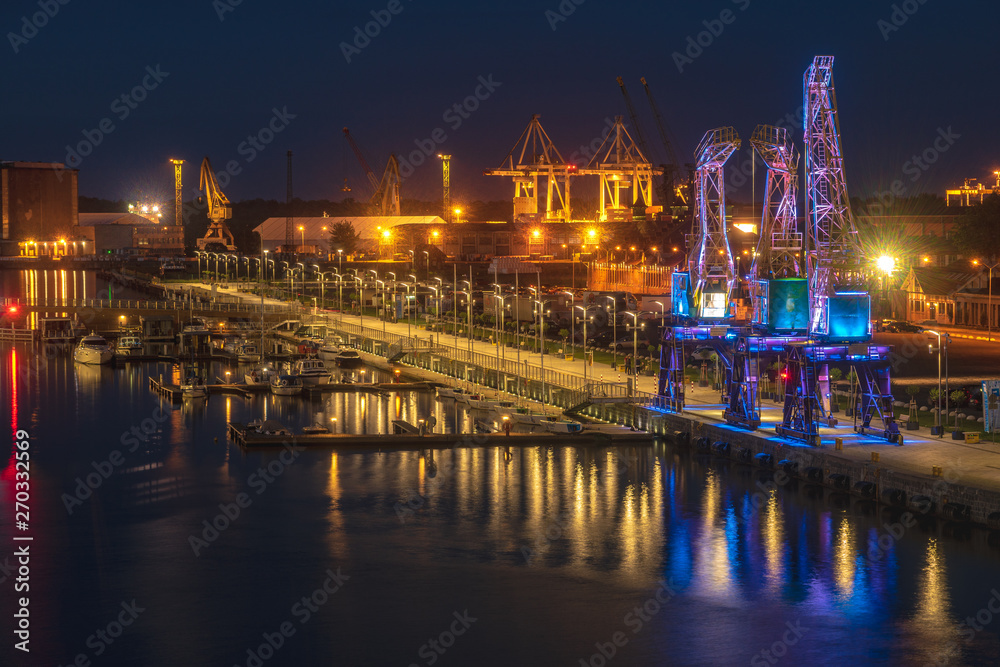 Illuminated old port cranes on a boulevard in Szczecin City at night