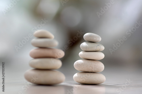 Harmony and balance  two cairns  simple poise pebbles on wooden light white gray background  simplicity rock zen sculpture