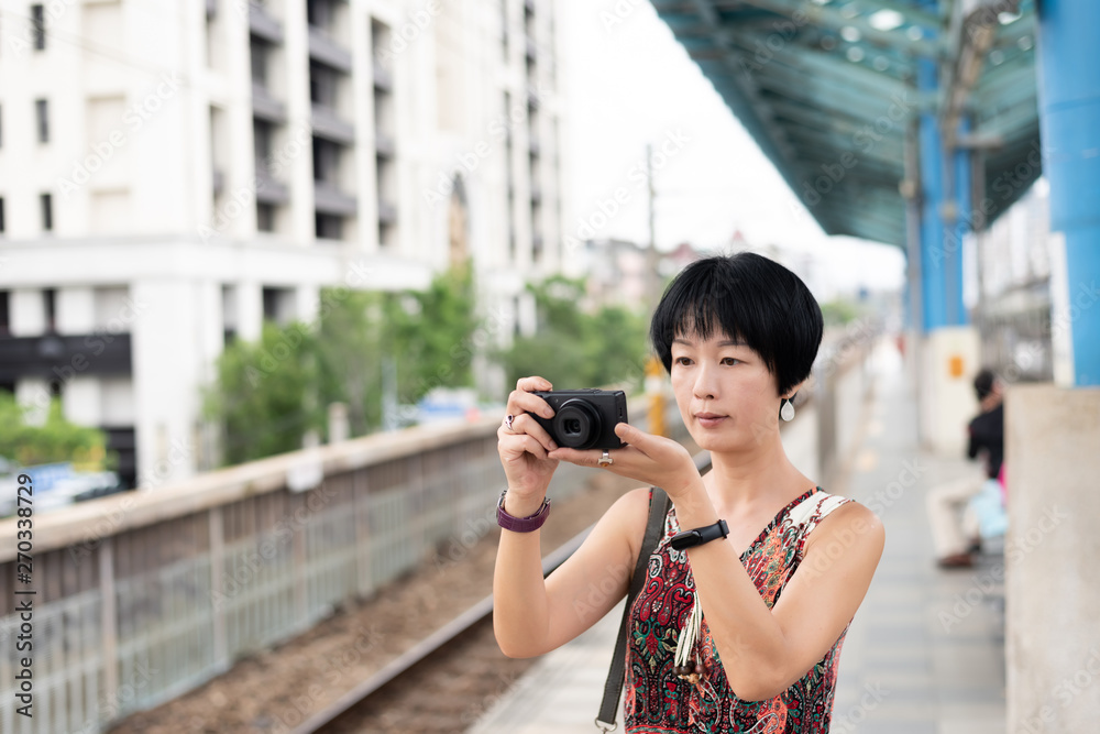 mature Asian woman using digital camera