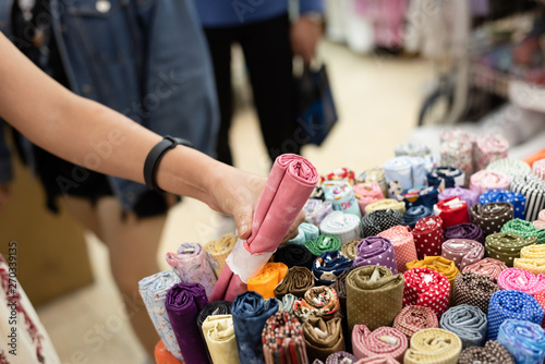 woman pick a roll of cloth at the fabric mall photo