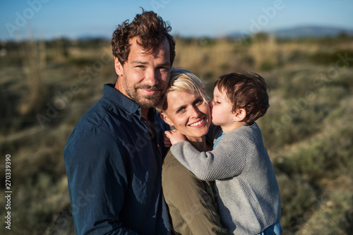 Young family with a small daughter standing outdoors in nature in Greece.