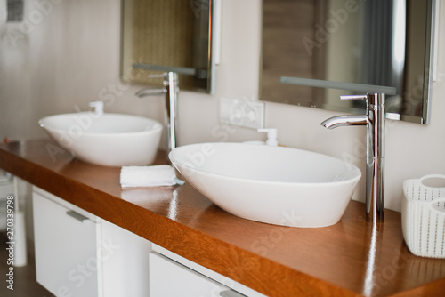 Modern stylish washbasins with chrome taps. Luxury lifestyle. Close-up  selective focus Wood texture