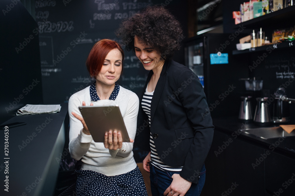 Two young businesspeople using tablet in office, start-up concept. Two young businesspeople using tablet in office, start-up concept.