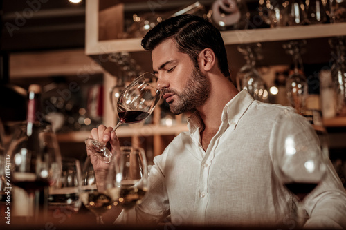 Concentrated expert going to taste red wine photo