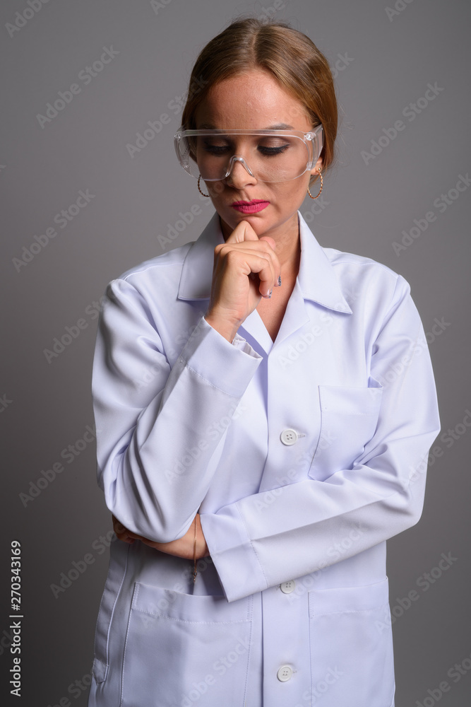Young beautiful woman doctor with blond hair wearing protective Young beautiful woman doctor with blond hair wearing protective