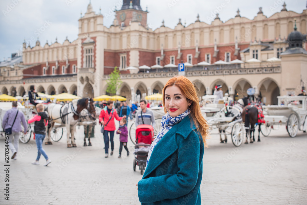 Obraz premium Tourism concept. Beautiful woman look at view of city streets, centre of city. Vacation in Krakow