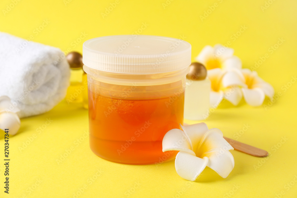 Container with sugaring paste for hair removal on color background Container with sugaring paste for hair removal on color background
