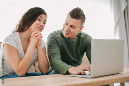 Adorable loving couple watching movie at home