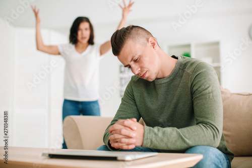 Young wife scolding her sad...