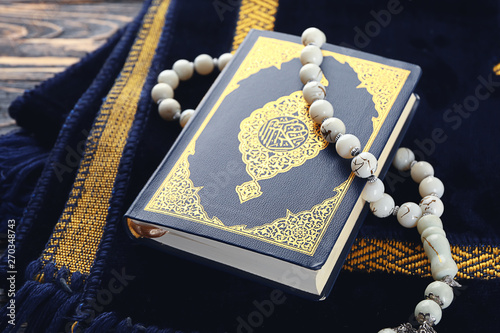 Fotografia Muslim prayer mat, beads and Koran on wooden background