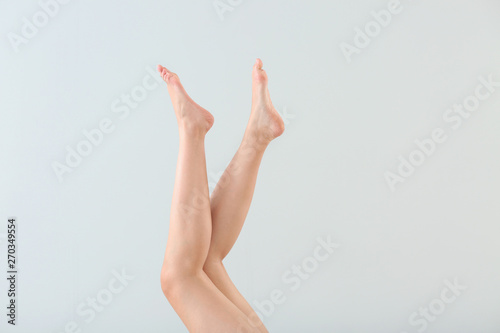 Legs of beautiful young woman after depilation on light background