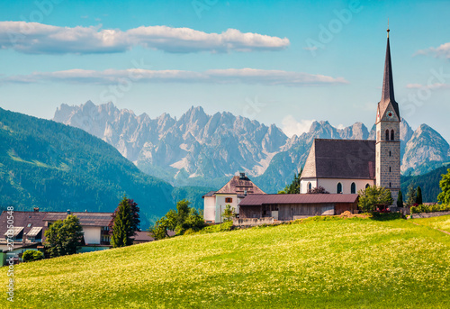Colorful summer scene of Pfarramt Catholic Church. Bright morning view of the Gosau village in the district of Gmunden in Upper Austria, Europe. Beauty of countryside concept background.