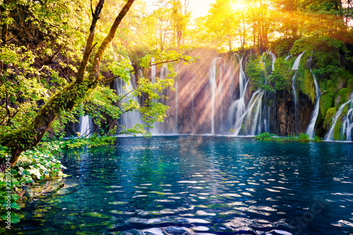 Last sunlight lights up the pure water waterfall on Plitvice National Park. Colorful spring scene of green forest with blue lake. Great countryside view of Croatia  Europe. 