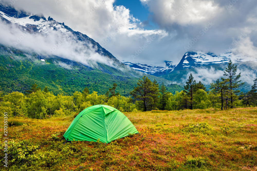 Green tourist tent near Innerdalsvatna lake. Colorful morning scene in Norway, Europe. Beauty of nature concept background. Artistic style post processed photo.
