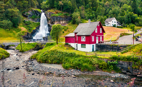 Great summer view with Large, popular waterfall Steinsdalsfossen on the Fosselva River. Picturesque morning scene of  village of Steine village, municipality of Kvam in Hordaland county, Norway. photo