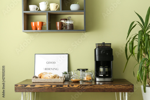 Fotografija Modern coffee machine and sweets on kitchen table