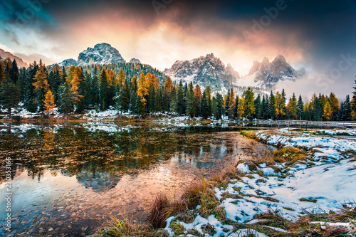 Dramatic sunrise on Antorno lake. Colorful autumn morning in Dolomite Alps, Province of Belluno, Italy, Europe. Artistic style post processed photo.