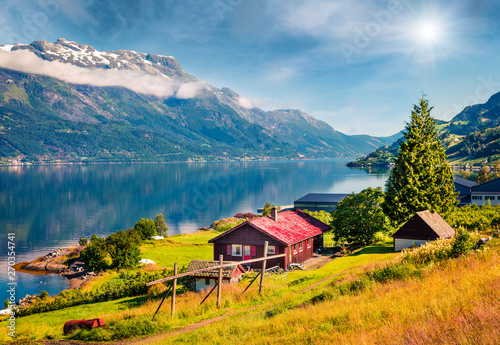 Sunny summer scene in Lofthus village, Hordaland county, Norway. Great morning view of Hardangerfjord fjord. Beauty of countryside concept background. photo