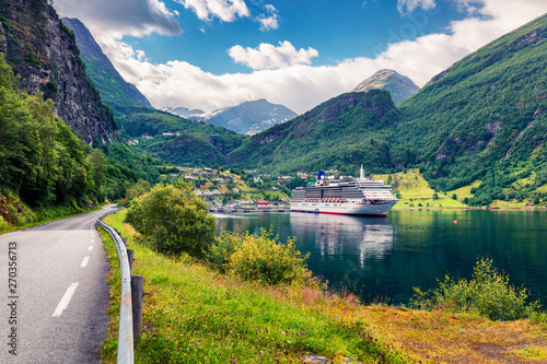 Sunny summer scene of Geiranger port, western Norway. Splendid view of Sunnylvsfjorden fjord. Traveling concept background. Artistic style post processed photo.