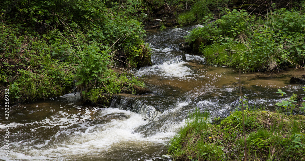 Mountain stream, River deep in mountain forest, Mountain creek cascade with fresh green moss on the stones Mountain stream, River deep in mountain forest, Mountain creek cascade with fresh green moss on the stones