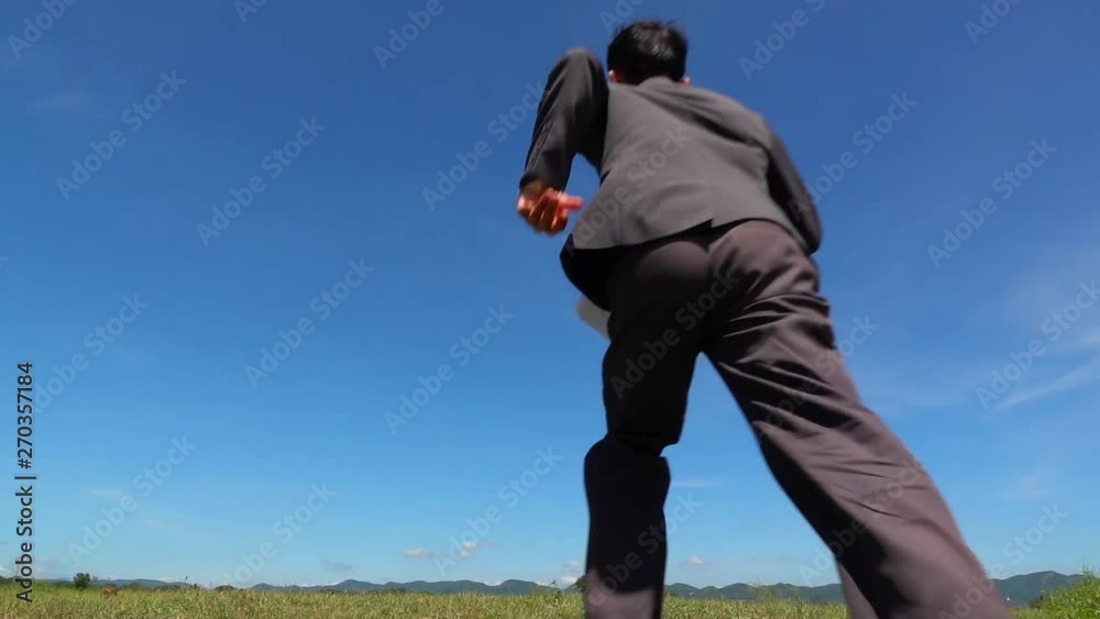 A business man jumping slow motion and cloud sky background. A business man jumping slow motion and cloud sky background.
