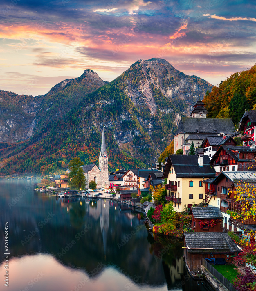 Fototapeta premium Dramatic autumn sunset on Hallstatt lake. Impressive evening viev of Hallstatt village, in Austria's mountainous Salzkammergut region, Austria. Beauty of countryside concept background.