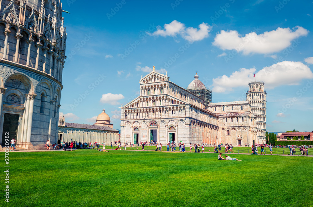 Splendid spring view of famous Leaning Tower in Pisa. Sunny morning scene with hundreds of tourists in Piazza dei Miracoli (Square of Miracles), Italy, Europe. Traveling concept background.