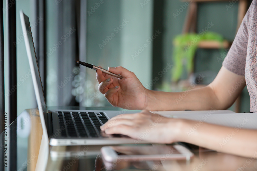 Side view of female hand typing keyboard with copy space in cafe. Office table background ideas and business concept.