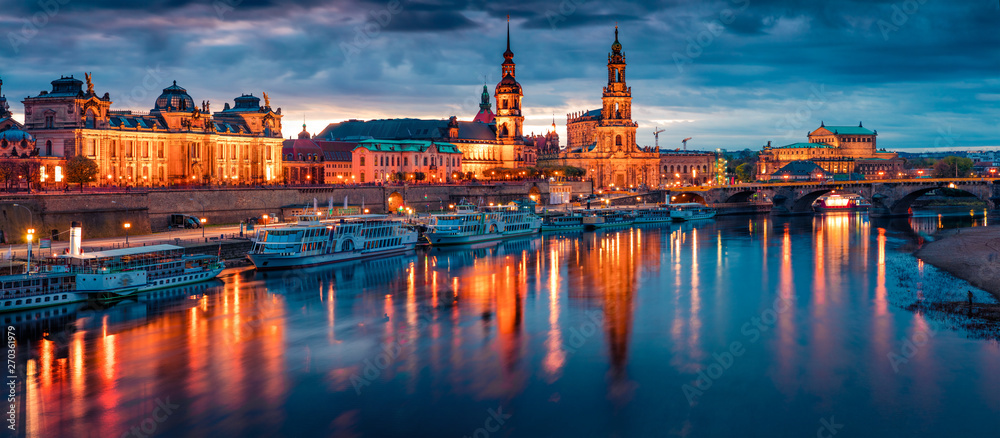 Fantastic evennig panorama of Cathedral of the Holy Trinity or Hofkirche, Bruehl's Terrace or The Balcony of Europe. Dramatic autumn sunset on Elbe river in Dresden, Saxony, Germany, Europe.