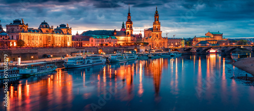 Fantastic evennig panorama of Cathedral of the Holy Trinity or Hofkirche, Bruehl's Terrace or The Balcony of Europe. Dramatic autumn sunset on Elbe river in Dresden, Saxony, Germany, Europe.