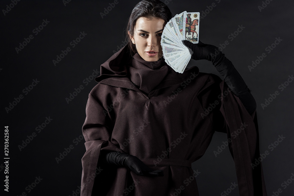 front view of woman in death costume holding tarot cards isolated on black  Stock Photo | Adobe Stock