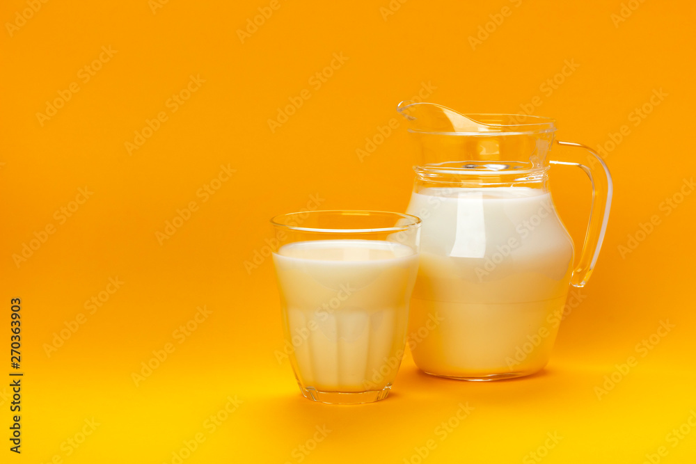 Jar and glass of milk isolated on yellow background with copy space for text, dairy product concept Jar and glass of milk isolated on yellow background with copy space for text, dairy product concept