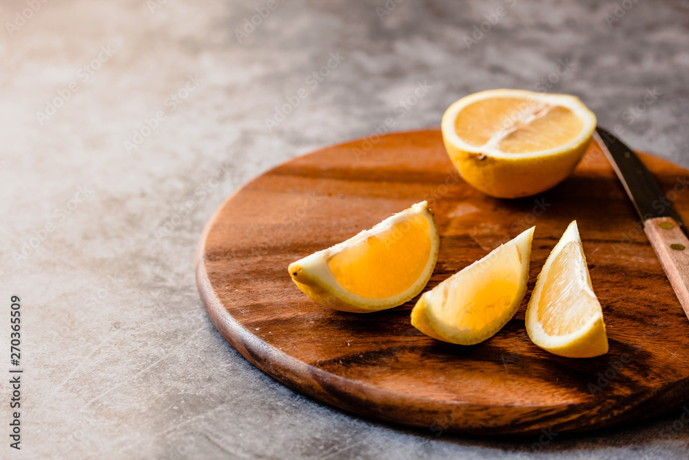 peace of lemon on a wooden board, gray background peace of lemon on a wooden board, gray background