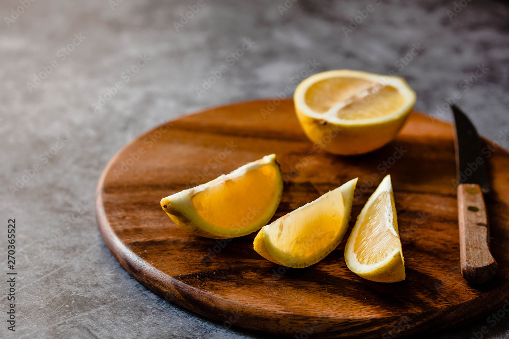 peace of lemon on a wooden board, gray background