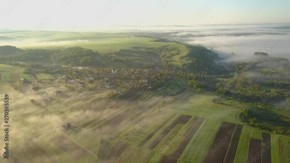 Aerial view of morning for over village houses on green spring hills. Aerial view of morning for over village houses on green spring hills.