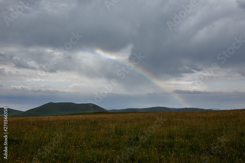 rainbow on a background of clouds in the mountains