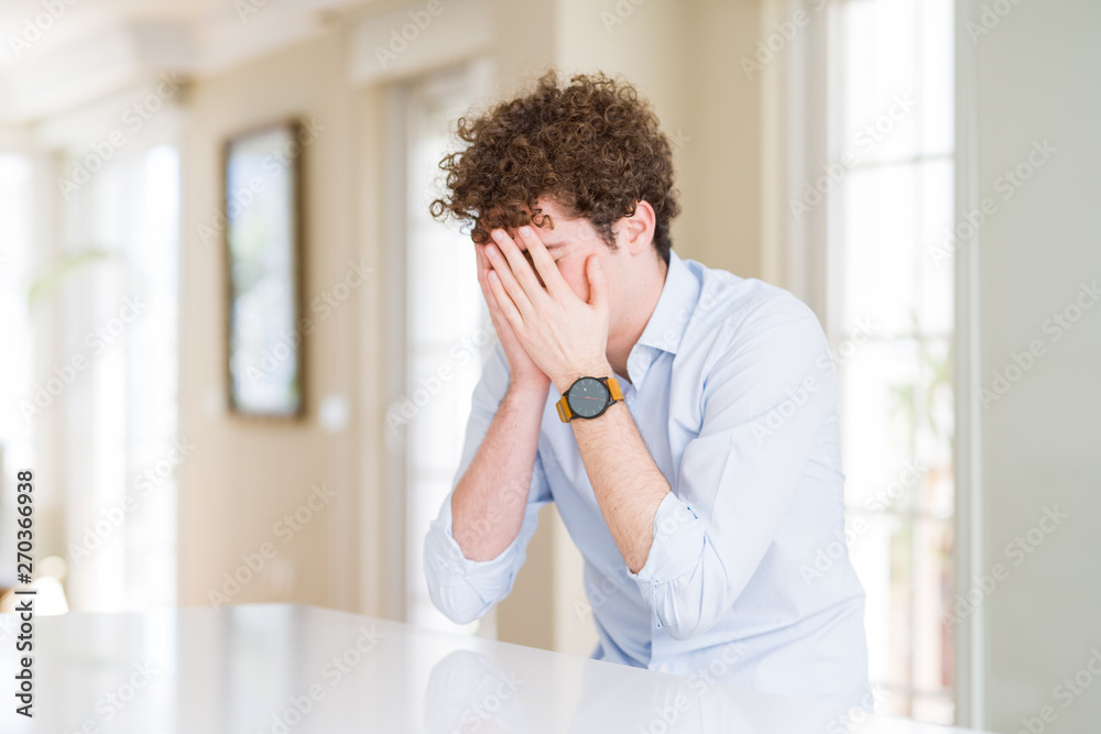 Young business man with curly read head with sad expression covering face with hands while crying. Depression concept. Young business man with curly read head with sad expression covering face with hands while crying. Depression concept.