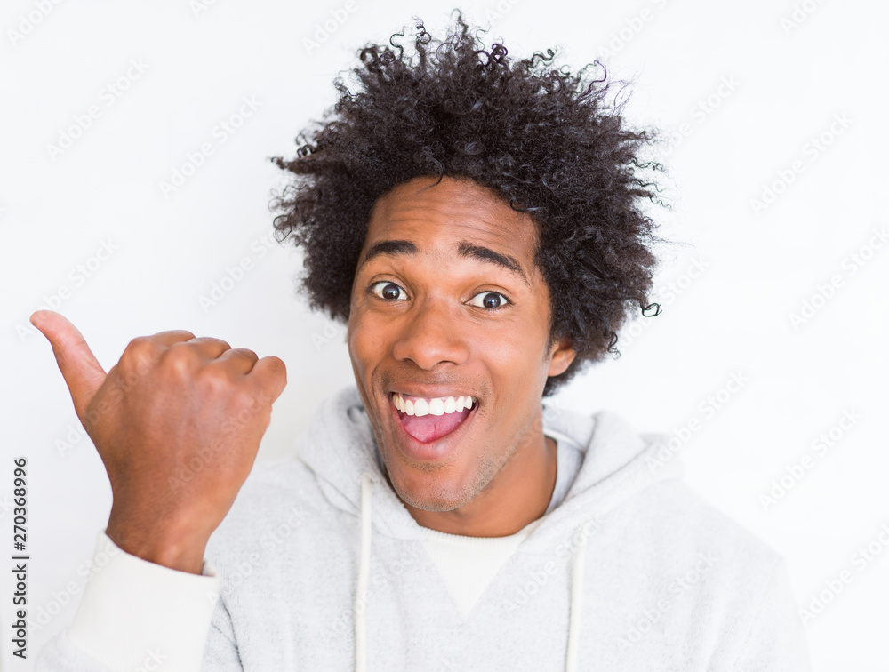 African American man over white isolated background pointing and showing with thumb up to the side with happy face smiling African American man over white isolated background pointing and showing with thumb up to the side with happy face smiling