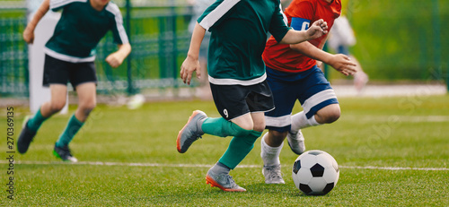 Children Play Football Tournament Game. Young Boys Running and Kicking Football Ball on Grass Sports Field © matimix