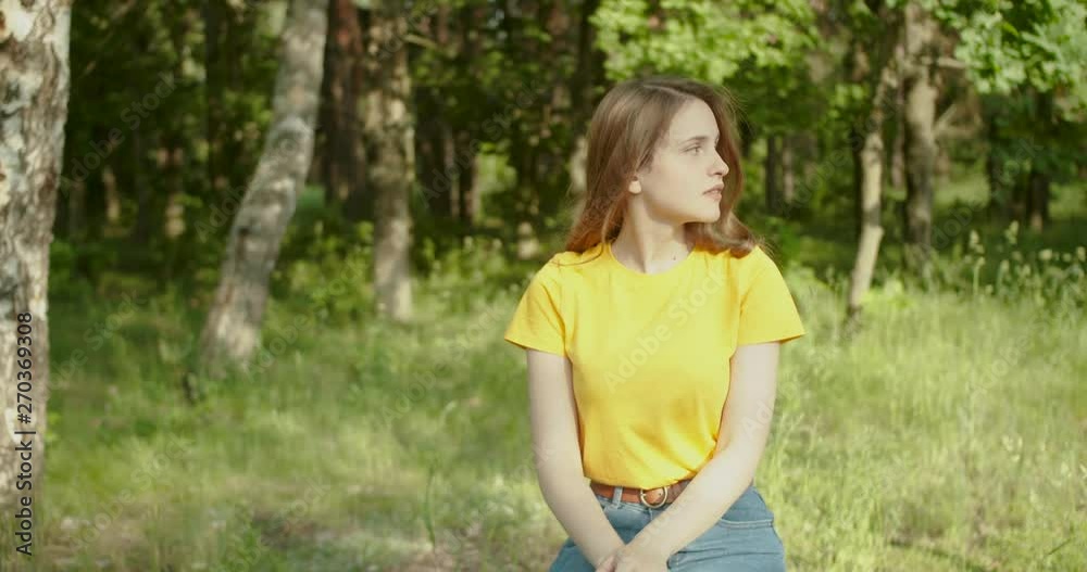Beautiful girl smiling and looking at the camera in the forest Beautiful girl smiling and looking at the camera in the forest