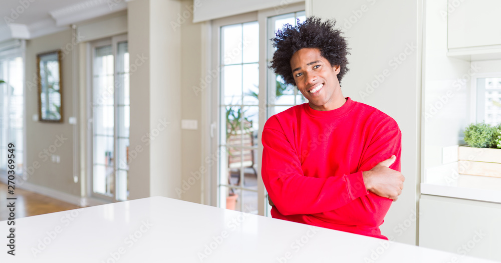 African American man wearing casual red sweatshirt happy face smiling with crossed arms looking at the camera. Positive person.