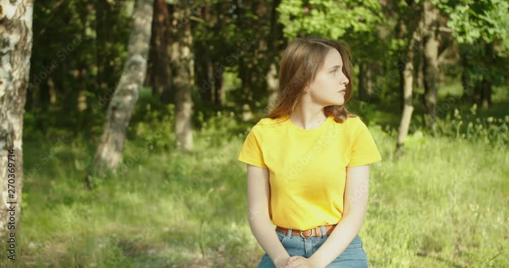 Beautiful girl smiling and looking at the camera in the forest Beautiful girl smiling and looking at the camera in the forest